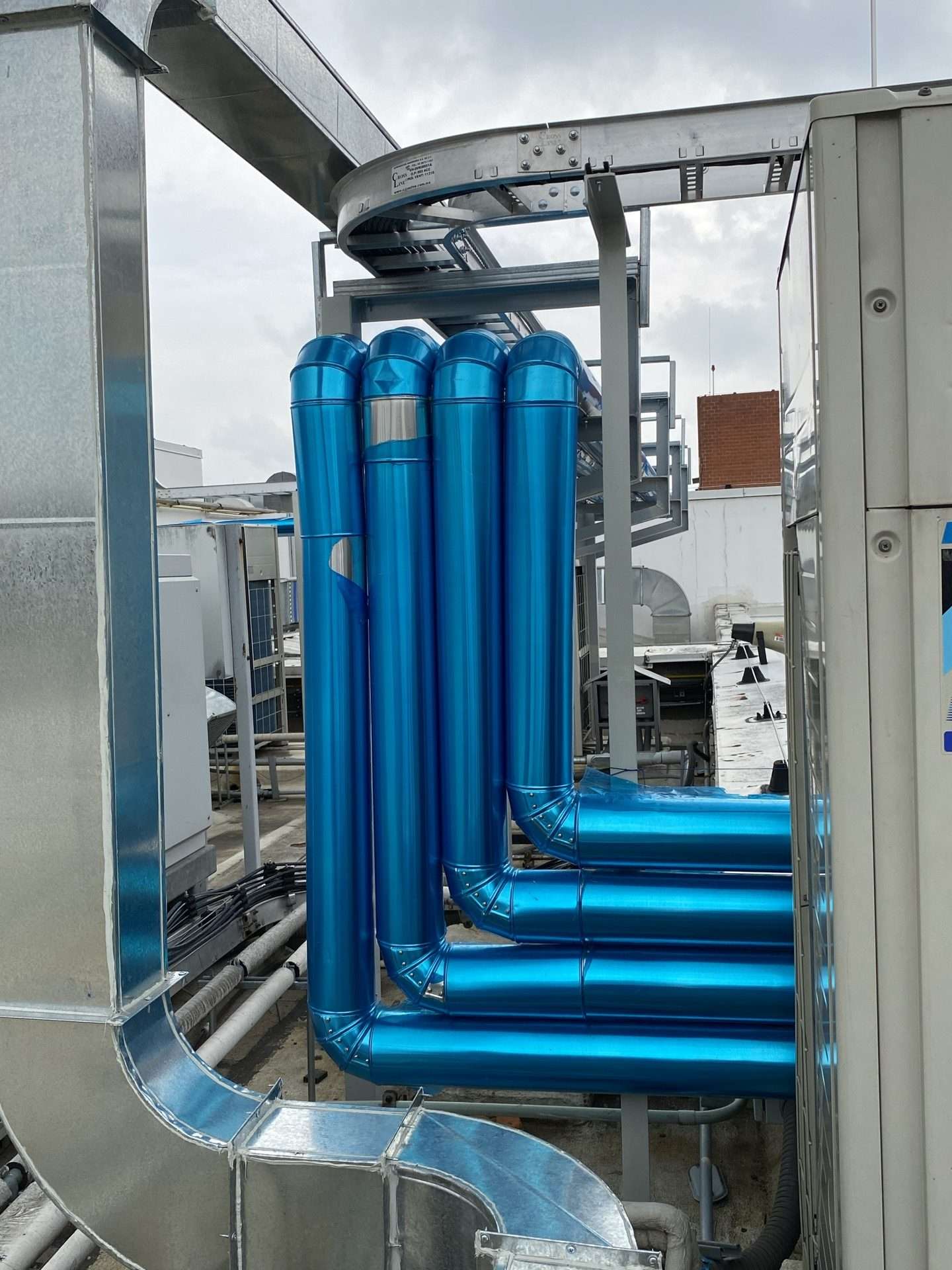 Tubería aislada de agua fría y caliente sobre la azotea de una planta farmacéutica